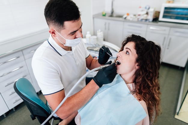 Mulher recebendo os dentes limpos no dentista