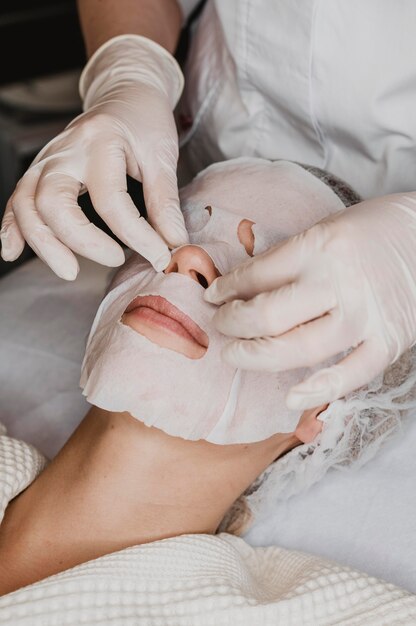 Mulher recebendo tratamento com máscara de pele no spa