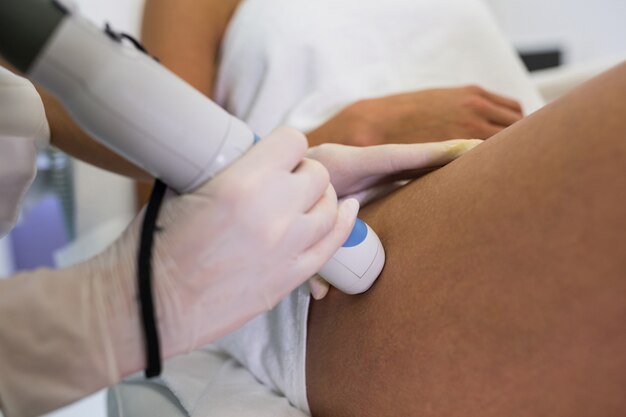 Mulher recebendo tratamento de depilação a laser na coxa