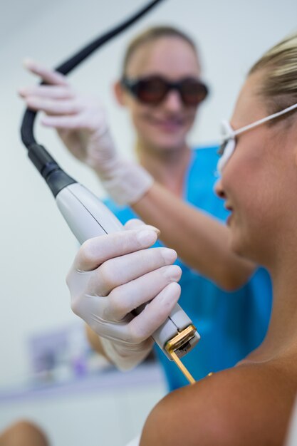 Mulher recebendo tratamento de depilação a laser no ombro