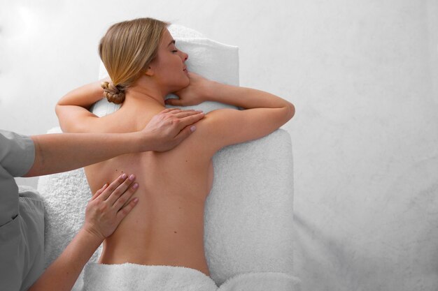 Mulher recebendo uma massagem nas costas do massagista