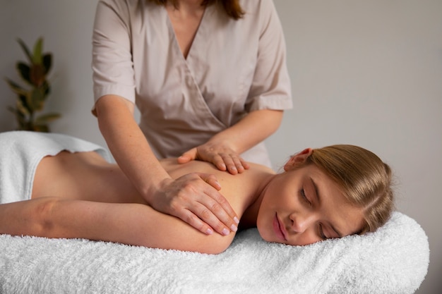 Foto grátis mulher recebendo uma massagem nas costas do massagista