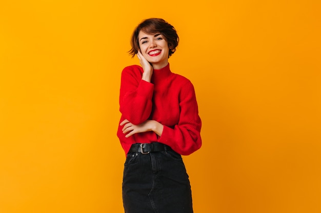 Mulher refinada com cabelo curto posando com um sorriso