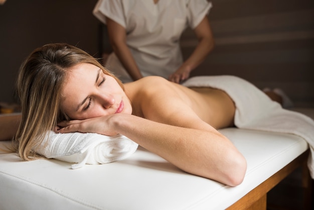 Mulher relaxada recebendo massagem no spa