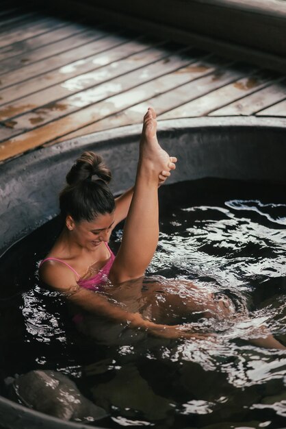 Mulher relaxando em banho ao ar livre redondo cuidados com a pele em banho quente