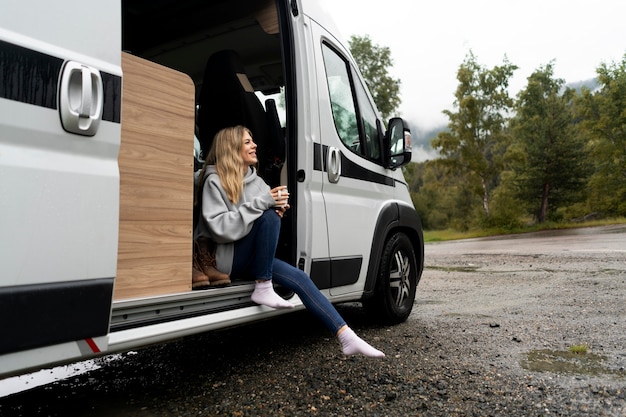 Foto grátis mulher relaxando em seu trailer à luz do dia