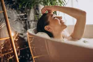 Foto grátis mulher relaxando na banheira com bolhas