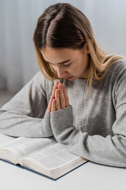 Mulher rezando com a bíblia