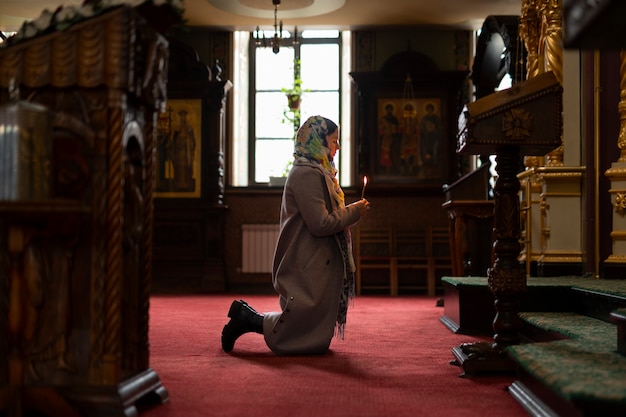 Mulher rezando na igreja para peregrinação religiosa