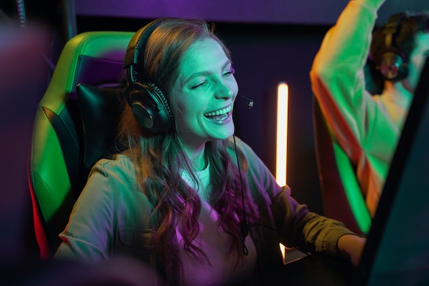 Mulher rindo de tiro médio jogando videogame