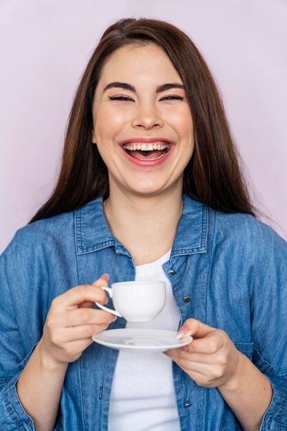 Mulher rindo enquanto toma café