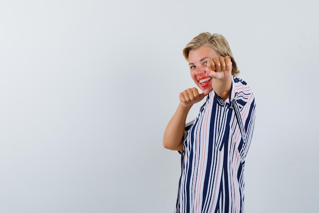 Foto grátis mulher rindo, levantando os punhos no fundo branco