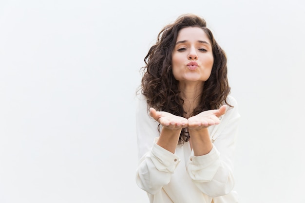 Mulher romântica positiva mandando beijo do ar