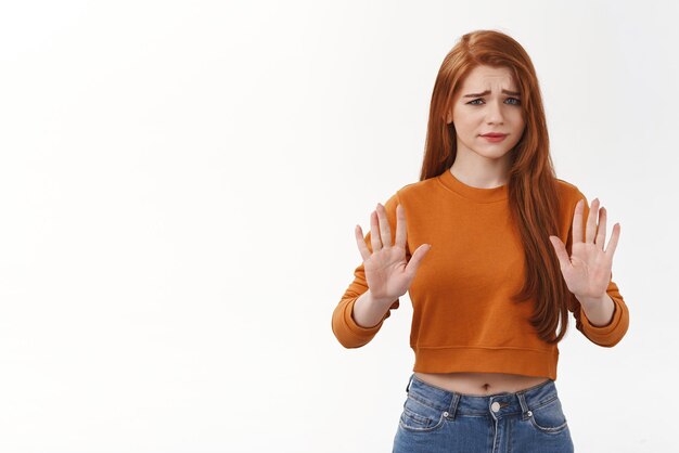 Mulher ruiva caucasiana bonita cética e não impressionada rejeitando oferta terrível não gosta e levanta as mãos no gesto de parada franzindo a testa com consternação e decepção não gosta de sugestão estranha