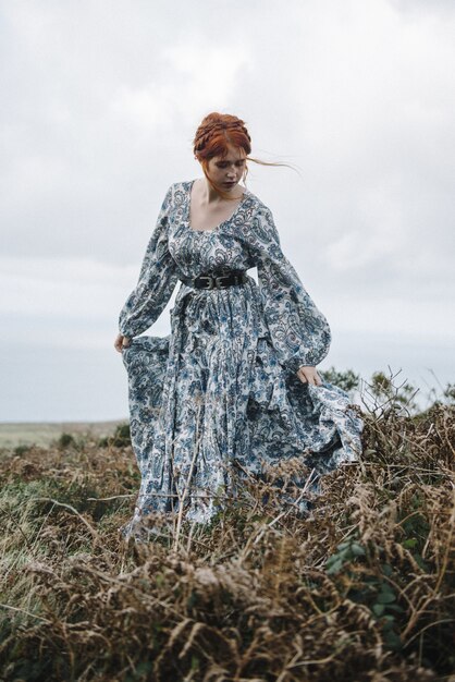 mulher ruiva com pele totalmente branca em um atraente vestido azul