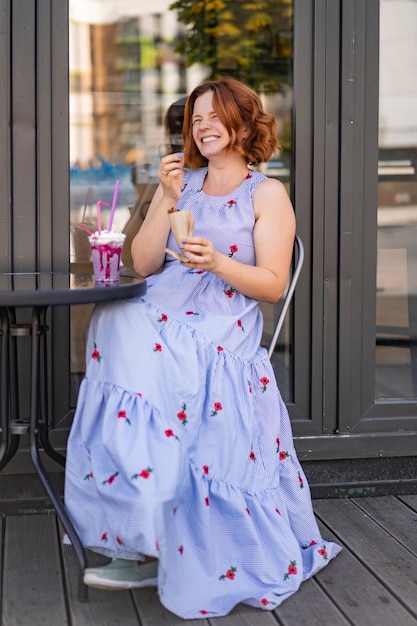 Foto grátis mulher ruiva em um café bebe um coquetel de verão, feliz, ri, sorri.