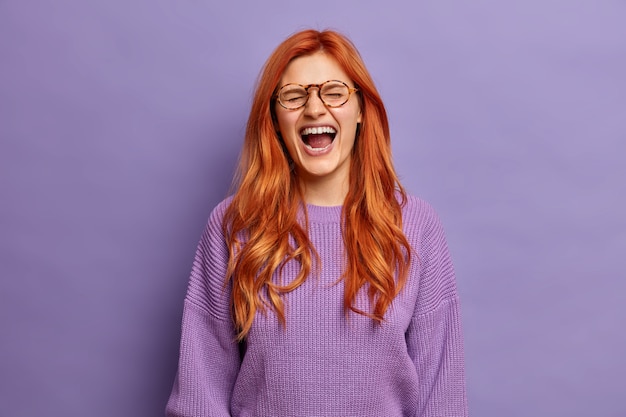 Foto grátis mulher ruiva emocional não consegue parar de rir e mantém a boca bem aberta.