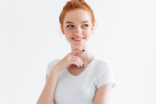 Mulher ruiva sorridente em t-shirt, olhando para longe