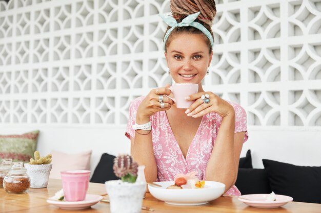 Mulher saboreando sobremesa e bebida no café