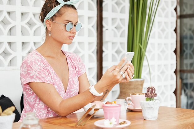 Mulher saboreando sobremesa e bebida no café