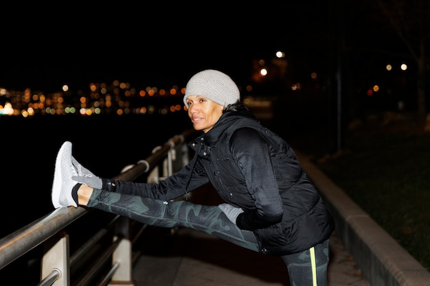 Foto grátis mulher se alongando à noite na cidade