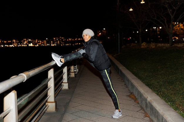 Foto grátis mulher se alongando à noite na cidade