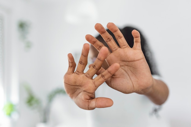 Mulher se defendendo de um ataque. pare. mãos estendidas. campanha para acabar com a violência contra as mulheres. mulher afro-americana levantou a mão para dissuadir com espaço de cópia