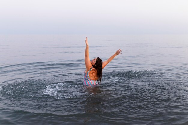 Mulher se divertindo na água na praia