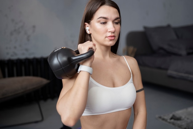 Foto grátis mulher se exercitando com kettlebell plano médio