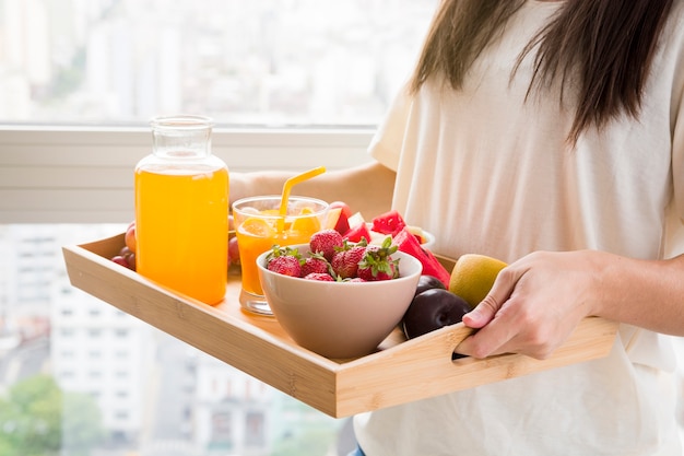 Mulher segura, vários, frutas, e, suco, garrafa, ligado, madeira, bandeja