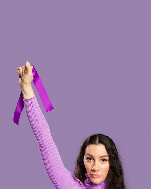 Mulher segurando a fita violeta na mão