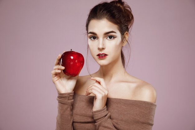 mulher segurando a maçã vermelha na rosa