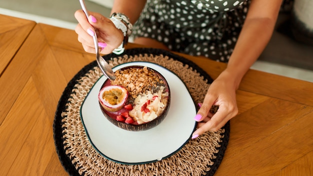 Foto grátis mulher segurando a placa de coco prato com tigela saboroso smoothie.