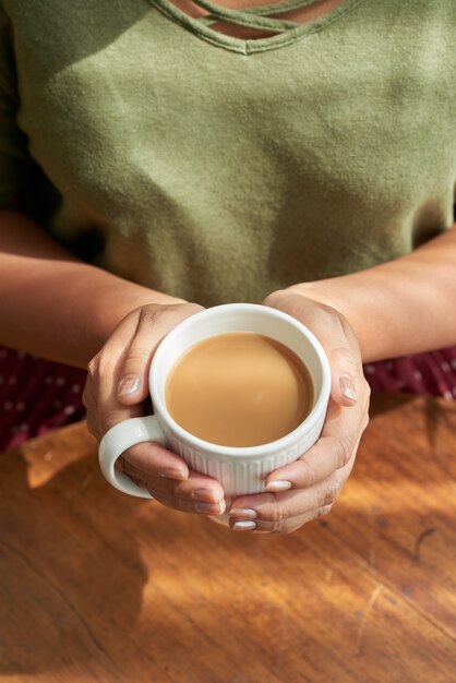 Mulher segurando a xícara de cappuccino