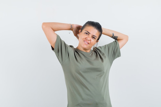 mulher segurando as mãos atrás da cabeça em uma camiseta e parecendo atraente