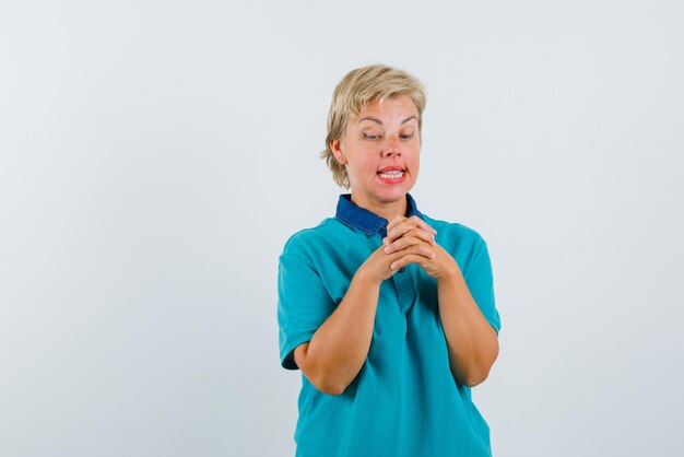 Mulher segurando as mãos entrelaçadas no fundo branco