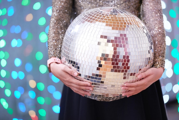 Mulher segurando bola de discoteca na festa