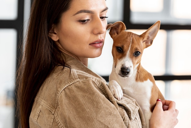 Mulher segurando cachorro fofo enquanto posava