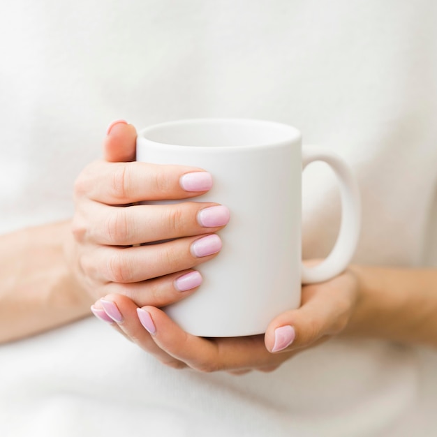 Mulher segurando caneca branca