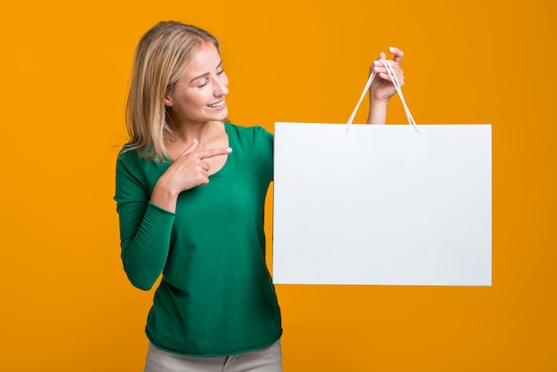 Foto grátis mulher segurando e olhando para uma grande sacola de compras