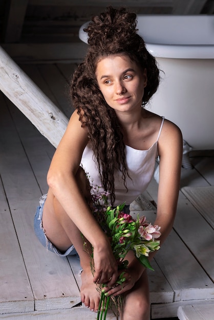 Foto grátis mulher segurando flores vista frontal