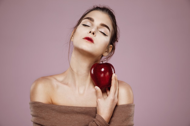 Mulher segurando grande maçã vermelha na rosa