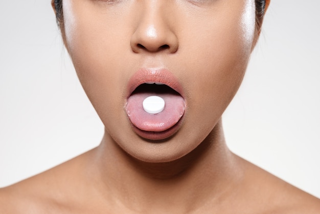 Foto grátis mulher segurando o comprimido na boca