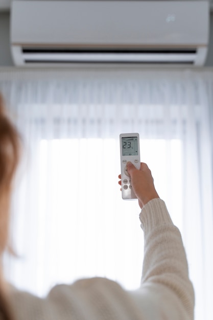 Mulher segurando o controle remoto para ligar o aquecedor