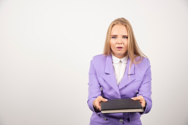 Mulher segurando o tablet fechado em branco.