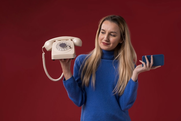 Mulher segurando o telefone antigo e novo