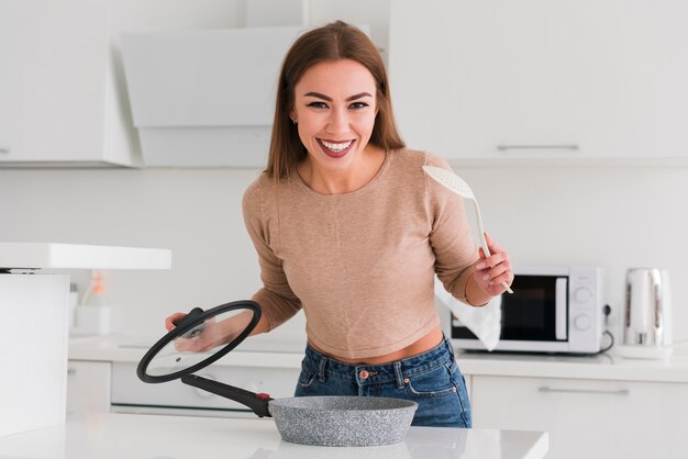 Mulher segurando objetos de cozinha nas mãos