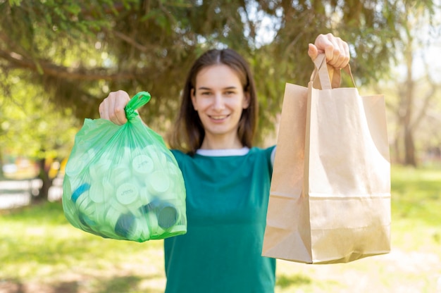 Mulher segurando sacos de papel e plástico