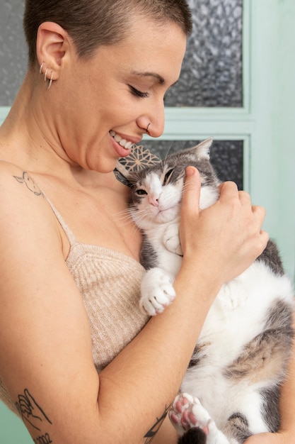 Mulher segurando seu adorável gatinho em casa