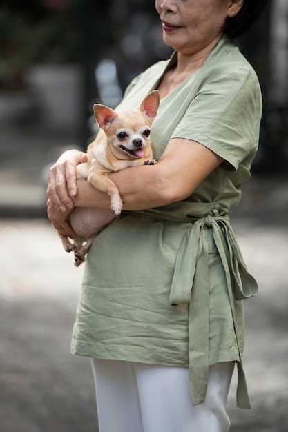 Foto grátis mulher segurando seu cachorro ao ar livre